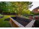 Landscaped backyard featuring a raised garden bed, a play set, and lush foliage at 2270 Abbey Cove Ct, Marietta, GA 30062