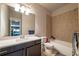 Neutral toned bathroom with a granite countertop, framed mirror, and tub with tiled wall at 2270 Abbey Cove Ct, Marietta, GA 30062