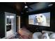 Home theater room with projector screen, theater-style seating, and adjacent bathroom at 2270 Abbey Cove Ct, Marietta, GA 30062