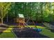 Backyard with wooden playset featuring a slide, swing, and climbing structure, perfect for outdoor fun at 2270 Abbey Cove Ct, Marietta, GA 30062