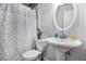 Cozy bathroom with a classic pedestal sink, toilet, and charming leaf-patterned shower curtain at 4061 Newman Ellis Rd, Douglasville, GA 30134