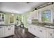 A brightly-lit kitchen leading to dining area, featuring white cabinets and modern black appliances at 4061 Newman Ellis Rd, Douglasville, GA 30134