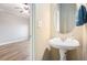 Half bathroom features a pedestal sink, round mirror, and views of the bedroom at 527 Pringle Dr, Suwanee, GA 30024