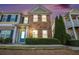 Beautiful townhome showcasing a brick facade, blue door, manicured landscaping, and a welcoming entrance at 527 Pringle Dr, Suwanee, GA 30024