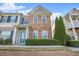 Well-maintained townhome with a brick front, vibrant landscaping, and a welcoming blue front door at 527 Pringle Dr, Suwanee, GA 30024