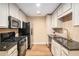 Modern kitchen with stainless appliances, granite counters, white cabinets, and tile backsplash at 527 Pringle Dr, Suwanee, GA 30024