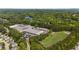Wide aerial perspective highlighting a mix of houses, commercial area, sports field, and a serene lake nearby at 2106 Berryhill Se Cir, Smyrna, GA 30082