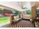 Covered back porch featuring a fan, outdoor seating, and views of the lush backyard at 2106 Berryhill Se Cir, Smyrna, GA 30082