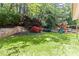 Sprawling backyard featuring lush landscaping, a play set, and mature trees at 2106 Berryhill Se Cir, Smyrna, GA 30082