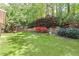 Beautifully landscaped backyard with lush green grass, brick retaining wall, and colorful shrubbery at 2106 Berryhill Se Cir, Smyrna, GA 30082