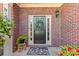Inviting front door framed by brick, enhanced with a wreath, decorative rug, and potted plants for a warm welcome at 2106 Berryhill Se Cir, Smyrna, GA 30082