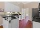 Well-lit kitchen with stainless steel appliances, black countertops, white cabinetry, and hardwood flooring at 2106 Berryhill Se Cir, Smyrna, GA 30082