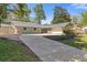 Charming single-story home with a stone facade, light-green wood siding, and a spacious concrete driveway at 350 Somerset Se Ln, Marietta, GA 30067