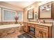 Bathroom featuring a double sink vanity, soaking tub, and natural light at 469 Kimberly Ct, Mcdonough, GA 30252