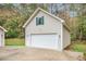 Detached garage with white door, green shutters, and a spacious driveway at 469 Kimberly Ct, Mcdonough, GA 30252