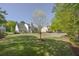Spacious backyard featuring a large lawn, landscaping, mature trees, and home's exterior at 513 Huntgate Rd, Woodstock, GA 30189