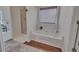 Bathroom featuring a jacuzzi tub, shower, hardwood flooring, and window at 513 Huntgate Rd, Woodstock, GA 30189
