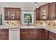 Close-up of the kitchen featuring wood cabinets, granite countertops, tiled backsplash, and stainless steel appliances at 513 Huntgate Rd, Woodstock, GA 30189