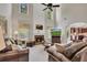 Spacious living room with a fireplace, tall windows, and comfortable seating arrangement at 513 Huntgate Rd, Woodstock, GA 30189