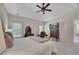 A spacious bedroom with a tray ceiling, ceiling fan, carpet floors, and a TV at 513 Huntgate Rd, Woodstock, GA 30189