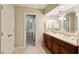 Bathroom featuring dual sinks, vanity storage, decorative mirrors, and a tile floor at 640 Sibley Se Frst, Marietta, GA 30067