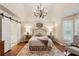 Elegant main bedroom with vaulted ceiling, chandelier, hardwood floors, and ensuite bathroom at 640 Sibley Se Frst, Marietta, GA 30067