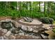 Serene backyard retreat with a gentle waterfall, flagstone lounging area, and mature trees at 104 Fairway Overlook, Woodstock, GA 30188