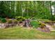 Lush backyard with tiered landscaping, featuring a beautiful waterfall and ample greenery at 104 Fairway Overlook, Woodstock, GA 30188