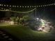 Stone steps ascend through a beautifully landscaped backyard illuminated by string lights at 104 Fairway Overlook, Woodstock, GA 30188