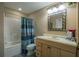 Bathroom features a shower-tub combination with a striped curtain, vanity with sink, and decorative mirror at 104 Fairway Overlook, Woodstock, GA 30188