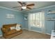 Well-lit bedroom features a cozy loveseat, white plantation shutters, and a decorative 'kindness' sign at 104 Fairway Overlook, Woodstock, GA 30188