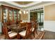 Elegant dining room with a glass-top table, seating for six, and a stylish china cabinet at 104 Fairway Overlook, Woodstock, GA 30188