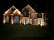 Beautiful brick home with manicured lawn and professional lighting at 104 Fairway Overlook, Woodstock, GA 30188