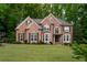 Stately brick home with manicured lawn, elegant windows, and a basketball hoop in the driveway at 104 Fairway Overlook, Woodstock, GA 30188