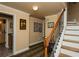 Hallway with staircase, wine themed wall art, and access to bar area with a wine fridge at 104 Fairway Overlook, Woodstock, GA 30188