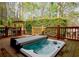 Relaxing hot tub on wooden deck with privacy landscaping, perfect for enjoying the outdoors at 104 Fairway Overlook, Woodstock, GA 30188