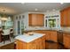 Well-lit kitchen with a center island, wooden cabinetry, and open access to a dining area at 104 Fairway Overlook, Woodstock, GA 30188