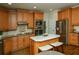 Modern kitchen with wood cabinets, an island with barstool seating, and stainless steel appliances at 104 Fairway Overlook, Woodstock, GA 30188