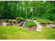 Scenic backyard landscaping with rock terraces, steps, waterfall, and lush trees at 104 Fairway Overlook, Woodstock, GA 30188