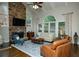 Bright living room features a stone fireplace, large windows, and vaulted ceiling at 104 Fairway Overlook, Woodstock, GA 30188