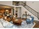 Open-concept living room with staircase, comfortable seating, and access to other rooms at 104 Fairway Overlook, Woodstock, GA 30188