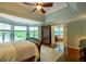 A spacious main bedroom boasts hardwood floors, ceiling fan, and large windows with outside views at 104 Fairway Overlook, Woodstock, GA 30188