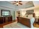 Main bedroom features beautiful hardwood floors, ceiling fan, and a large dresser with mirror at 104 Fairway Overlook, Woodstock, GA 30188