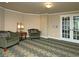 Sitting area with two armchairs with patterned pillows and french doors overlooking treed backyard at 104 Fairway Overlook, Woodstock, GA 30188
