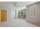 Bedroom featuring large windows, neutral carpet, a ceiling fan, and a side door at 1294 Fernwood Ne Cir, Brookhaven, GA 30319