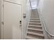 Carpeted staircase with a metal railing and a white entry door at 1294 Fernwood Ne Cir, Brookhaven, GA 30319