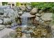 Backyard water feature with small waterfall, rockery, and lush greenery creating a peaceful outdoor oasis at 1294 Fernwood Ne Cir, Brookhaven, GA 30319