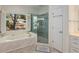 Bright bathroom featuring a jetted tub, glass enclosed shower, and many windows at 220 Autumn Sage Dr, Alpharetta, GA 30005