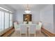 Formal dining room with white chairs, modern chandelier, and window shutters at 220 Autumn Sage Dr, Alpharetta, GA 30005