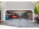 Open garage featuring gray walls, concrete floor, and a red car at 220 Autumn Sage Dr, Alpharetta, GA 30005